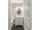 Well-lit half bathroom with a modern vanity, round mirror and dark hardwood floors at 267 Winthrow Creek Rd, Mooresville, NC 28115