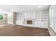Spacious living room showcasing a fireplace, built-in shelving and cabinets, and wood floors at 267 Winthrow Creek Rd, Mooresville, NC 28115