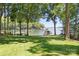 Green lawn stretches to the lakefront, revealing a private dock and tranquil water views at 2704 Apache Trl, Denver, NC 28037