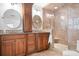 Luxurious bathroom featuring double sinks, granite countertops, and a walk-in shower with designer tile work at 2704 Apache Trl, Denver, NC 28037