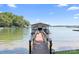 Wooden walkway leads to covered boat dock, offering direct access to the serene lake at 2704 Apache Trl, Denver, NC 28037