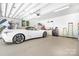 Immaculate garage with a sleek white car parked inside, showcasing ample space and a well-organized layout at 2704 Apache Trl, Denver, NC 28037
