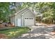 Detached garage with a clean, light-green exterior, featuring a double door and well-manicured landscaping at 2704 Apache Trl, Denver, NC 28037
