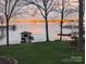 Scenic lake view featuring a boathouse and the tranquil water reflecting the sunset colors at 2704 Apache Trl, Denver, NC 28037