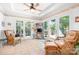 Bright sun room with wicker furniture and multiple doors leading to the deck, perfect for relaxing and enjoying the view at 2704 Apache Trl, Denver, NC 28037