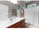 Bathroom with a white sink, cherry drawers, decorative mirror, and bathtub-shower combo at 2818 Levinfield Ct, Lincolnton, NC 28092