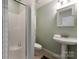 Small bathroom with a shower, pedestal sink, mirrored medicine cabinet, and toilet at 2818 Levinfield Ct, Lincolnton, NC 28092