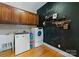 Laundry room with modern appliances, storage cabinets, and a chalkboard accent wall at 2818 Levinfield Ct, Lincolnton, NC 28092