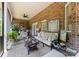 Relaxing porch with exposed brick wall, ceiling fan, comfortable seating, and elegant dining table at 2818 Levinfield Ct, Lincolnton, NC 28092