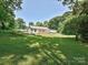 Backyard view of the house with a wooden deck and surrounded by mature trees, offering privacy and a serene atmosphere at 285 Hannah Ave, Salisbury, NC 28147