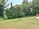 Expansive backyard featuring lush greenery and mature trees, offering privacy and space for activities at 285 Hannah Ave, Salisbury, NC 28147