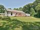 Exterior view of the house featuring a wooden deck, complemented by a well-maintained lawn and mature trees at 285 Hannah Ave, Salisbury, NC 28147