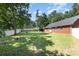 Green backyard featuring lush grass and mature trees, with a sturdy privacy fence at 2916 Northwood Dr, Monroe, NC 28110