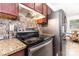 Close-up of kitchen with stainless steel appliances, mosaic backsplash, and granite countertops at 2916 Northwood Dr, Monroe, NC 28110