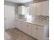 Bright kitchen featuring white cabinets, marbled countertops, and a stylish herringbone backsplash at 326 Gorrell St, Shelby, NC 28152