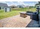 Paved patio with a fire pit and outdoor seating in a fenced backyard with green grass at 3313 Plum Dr, Monroe, NC 28110