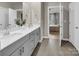 Bathroom with a double vanity, modern fixtures, and tile flooring leading to the Primary bedroom at 3313 Plum Dr, Monroe, NC 28110