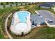 Aerial view of a community pool with ample seating, landscaping, and a clubhouse at 3313 Plum Dr, Monroe, NC 28110