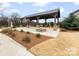 Community outdoor pavilion with a stone fire pit and manicured landscaping for social gatherings at 3313 Plum Dr, Monroe, NC 28110