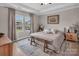 Well-lit main bedroom featuring a decorative rug, tray ceiling, two windows, and neutral tones at 3313 Plum Dr, Monroe, NC 28110