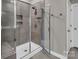 Tiled shower stall featuring a bench, clear glass door and modern fixtures in a well-lit bathroom at 3313 Plum Dr, Monroe, NC 28110