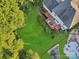 Aerial view of lush backyard with a wooden deck, mature trees, pool, and stone landscaping at 3705 Chesapeake Pl, Waxhaw, NC 28173