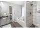 This bathroom features a separate shower and tub, a double sink with granite countertop, and neutral tile at 3705 Chesapeake Pl, Waxhaw, NC 28173
