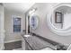 This bathroom features a double sink with granite countertop and a large framed round mirror at 3705 Chesapeake Pl, Waxhaw, NC 28173