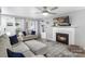 Comfortable living room featuring a fireplace, ceiling fan, and neutral decor with ample natural light at 3705 Chesapeake Pl, Waxhaw, NC 28173