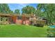 Manicured backyard featuring lush green grass, mature trees, and glimpses of a refreshing swimming pool, perfect for outdoor relaxation at 408 E Blume St, Landis, NC 28088