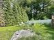 A backyard space with a table and chairs in a shaded area surrounded by lush green trees and grass at 408 E Blume St, Landis, NC 28088