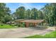 Ranch-style home featuring a covered parking area and a swimming pool surrounded by mature trees and landscaped grounds at 408 E Blume St, Landis, NC 28088