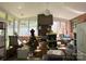 Spacious sunroom featuring many windows, a fireplace, and scattered personal items and furniture at 408 E Blume St, Landis, NC 28088