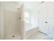 All-white bathroom featuring a separate shower and tub, as well as modern fixtures and finishes at 4230 Chatterleigh Dr, Monroe, NC 28110