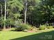 A serene backyard featuring lush greenery, mature trees, and well-maintained landscaping, creating a tranquil outdoor oasis at 44112 Harper Hearne Rd, New London, NC 28127