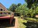 View of backyard, patio, and carport, surrounded by lush greenery at 44112 Harper Hearne Rd, New London, NC 28127