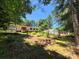 Landscaped backyard with greenhouse and partial view of exterior of home at 44112 Harper Hearne Rd, New London, NC 28127