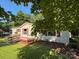 Exterior shot of home with manicured lawn, flowerbeds, and red shutters at 44112 Harper Hearne Rd, New London, NC 28127