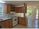 Functional kitchen layout with white appliances, laminate countertops, and warm wood cabinets at 44112 Harper Hearne Rd, New London, NC 28127