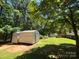 Exterior view of metal storage sheds next to lawn and home at 44112 Harper Hearne Rd, New London, NC 28127