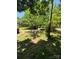 A spacious, sun-dappled yard with mature trees, covered parking, and manicured lawn, creating a peaceful outdoor area at 44112 Harper Hearne Rd, New London, NC 28127