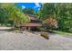 Exterior view of home from back of property with a gravel yard and lush surrounding foliage at 485 Johnson St, China Grove, NC 28023