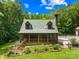 Two-story log cabin featuring a cozy porch and lovely landscaped yard; picturesque and inviting at 485 Johnson St, China Grove, NC 28023