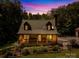 Charming cabin with a covered front porch and dormer windows against a colorful sunset backdrop at 485 Johnson St, China Grove, NC 28023