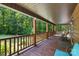 Expansive porch with wooden flooring, log railings, and comfortable seating, offering serene views of the surrounding greenery at 485 Johnson St, China Grove, NC 28023