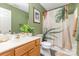 This full bathroom features a shower-tub combo, wooden cabinets, and green walls at 4894 Prowess Ln, Indian Land, SC 29707