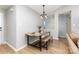 A dining area features a wooden table and bench with a decorative chandelier at 4894 Prowess Ln, Indian Land, SC 29707