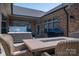 Inviting back patio with a hot tub, outdoor table with a fire pit, and a grill, perfect for entertaining at 5268 Courtyard Ln, Belmont, NC 28012