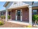 Charming brick front exterior with a covered porch and manicured landscaping at 5268 Courtyard Ln, Belmont, NC 28012