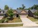 Charming brick home with a well-maintained lawn, mature trees, and an attached two-car garage at 5268 Courtyard Ln, Belmont, NC 28012